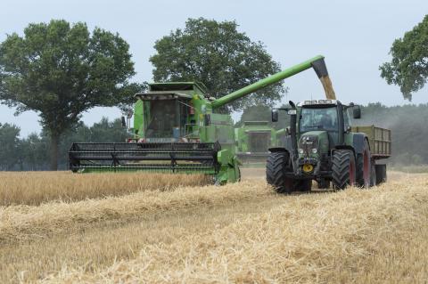 Drescher und Traktor bei der Getreideernte